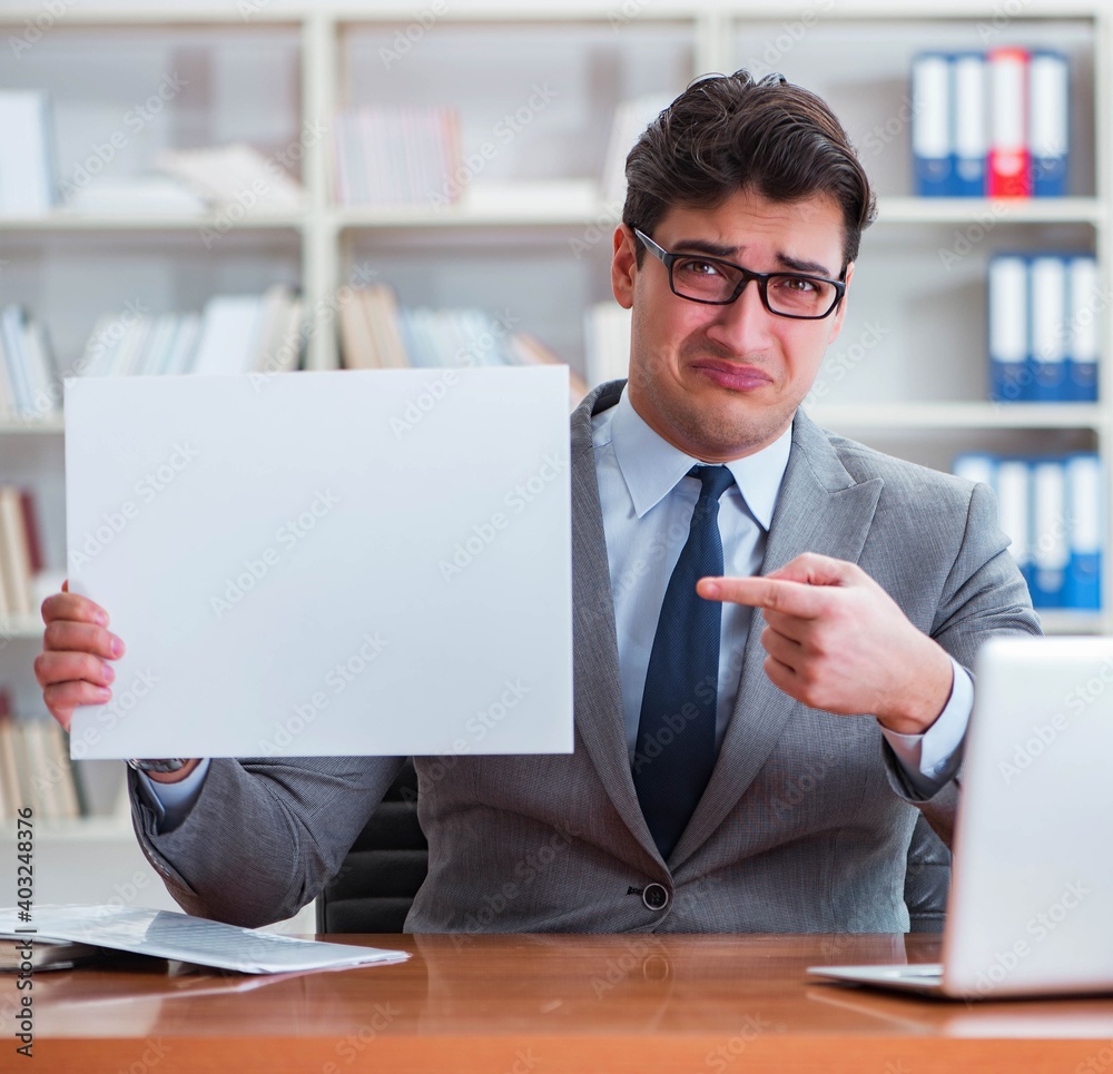 Businessman in office holding a blank message board Businessman in office holding a blank message board