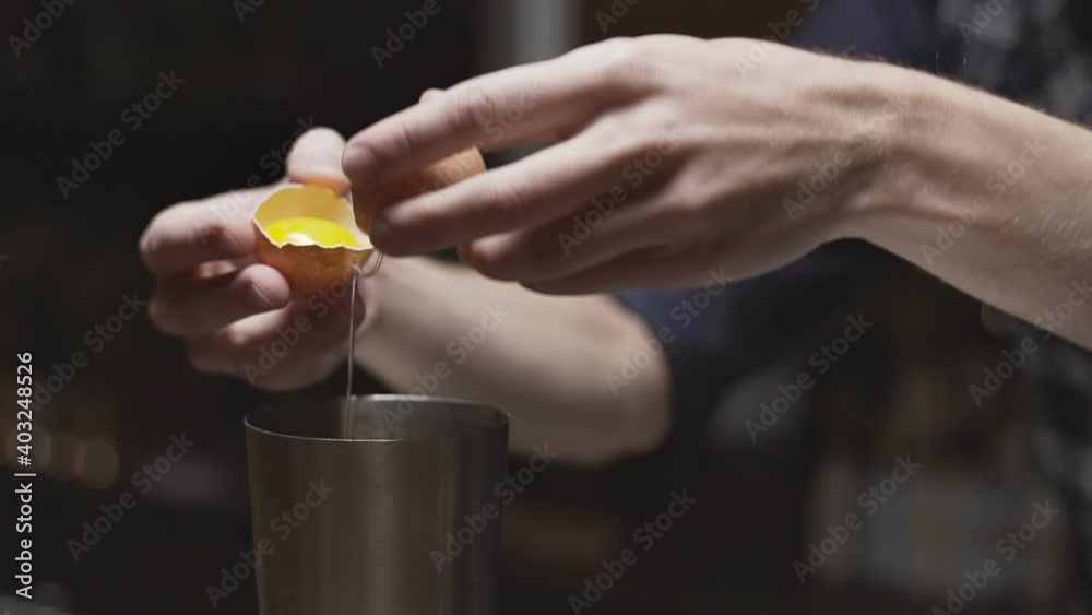 Bartender is adding egg white to shaker close up Bartender is adding egg white to shaker close up