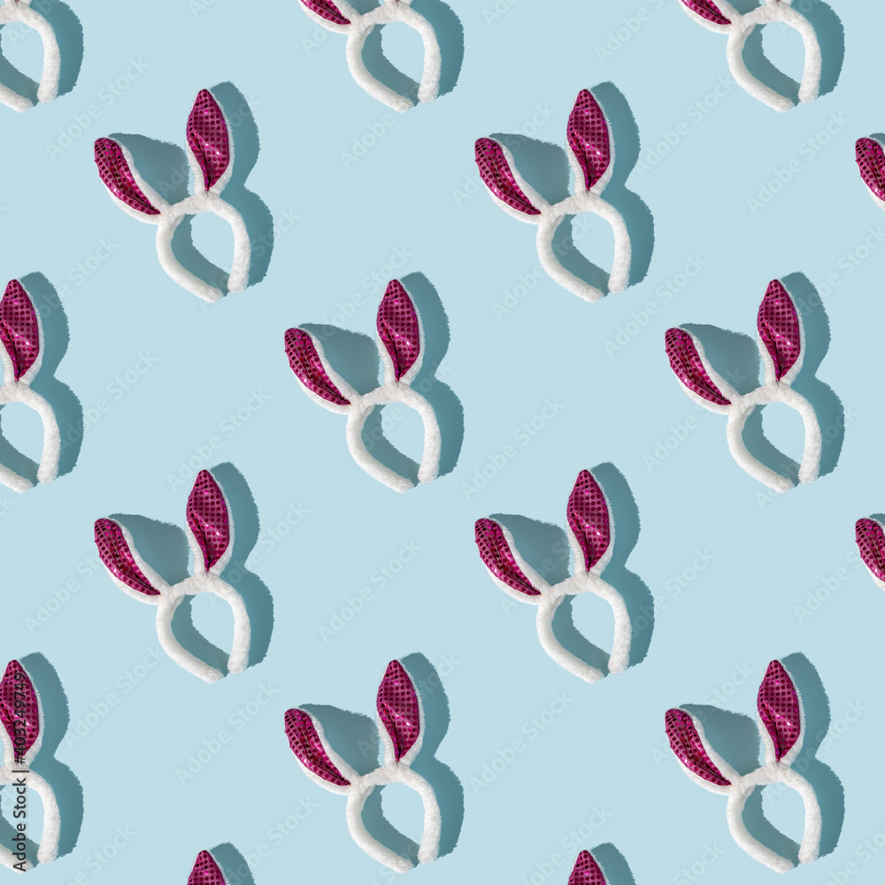 Easter pattern of pink and white bunny ears on blue background, top view, strong shadows Easter pattern of pink and white bunny ears on blue background, top view, strong shadows