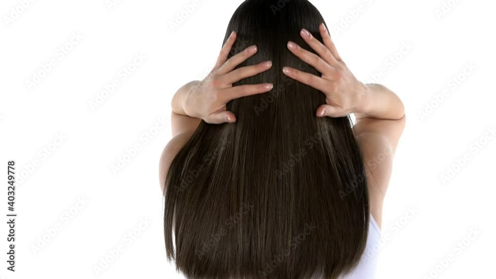 young brunette tossing her hair and turn with a smile to the camera on a white background young brunette tossing her hair and turn with a smile to the camera on a white background
