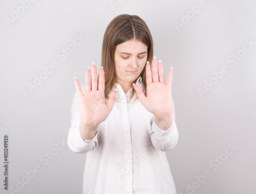 Pretty caucasian female with serious expressions asks you to be calm and attentive, Stop sign