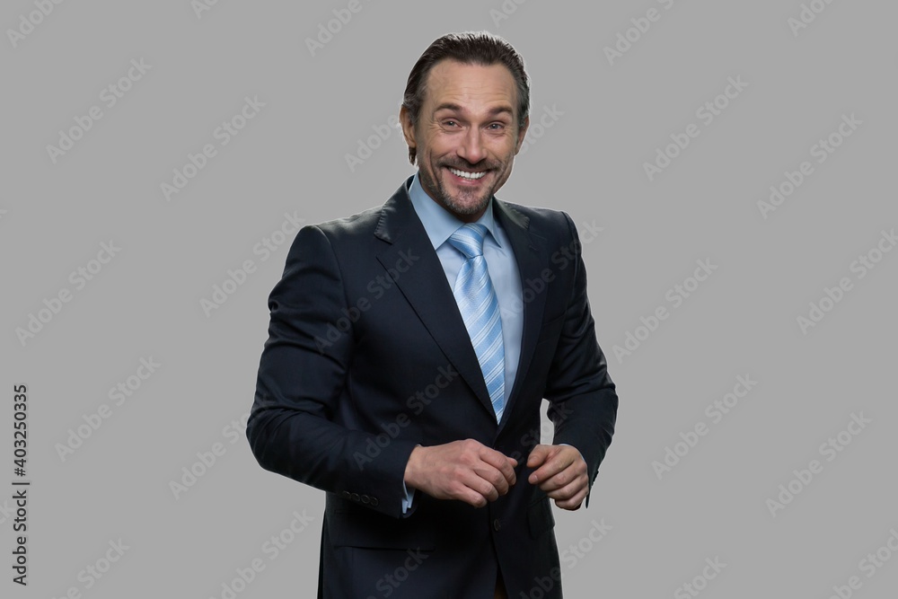 Businessman is laughing on gray background. Successful smiling businessman looking at camera. Businessman is laughing on gray background. Successful smiling businessman looking at camera.