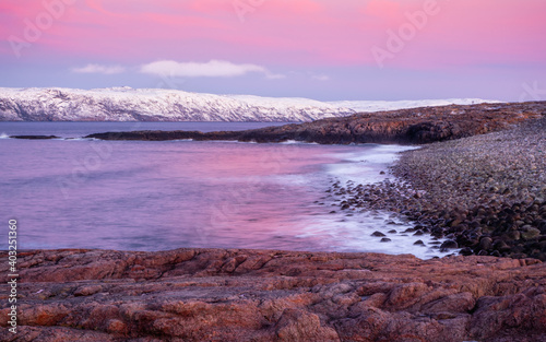 A rock cliff with a tidal shoreline. Wonderful panoramic mountain landscape on the Barents sea.