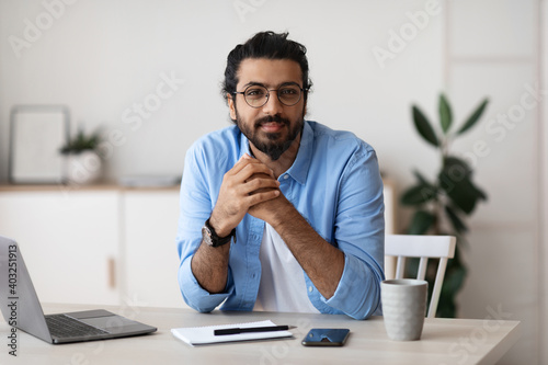 Millennial Freelancer. Portrait Of Young Arab Man At Desk In Home Office