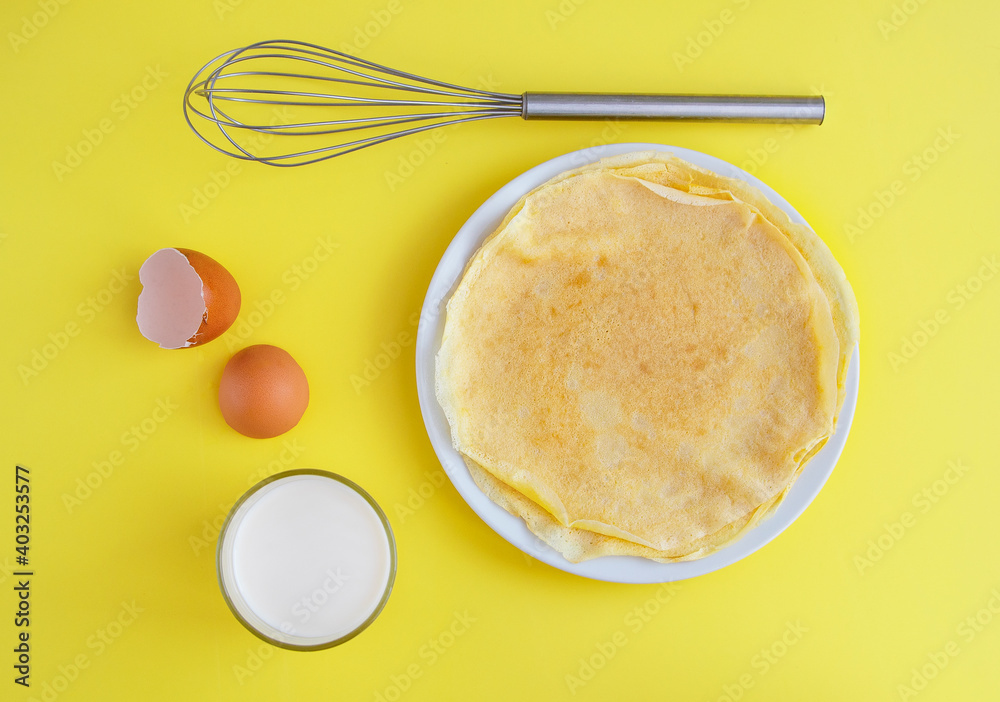 Flat composition with thin pancakes on bright yellow background Flat composition with thin pancakes on bright yellow background