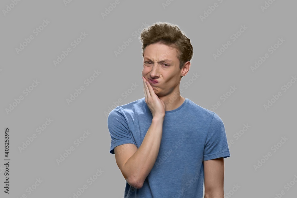 Upset teen boy having toothache. Emotional teenage boy suffering from tooth pain, front view. Upset teen boy having toothache. Emotional teenage boy suffering from tooth pain, front view.