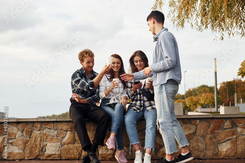 Coffee time. Group of young cheerful friends that is outdoors having fun together
