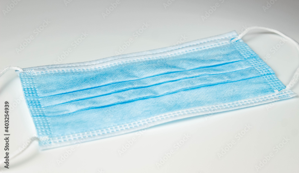 Blue medical mask on a white background. Protection against viruses and infections. Blue medical mask on a white background. Protection against viruses and infections.
