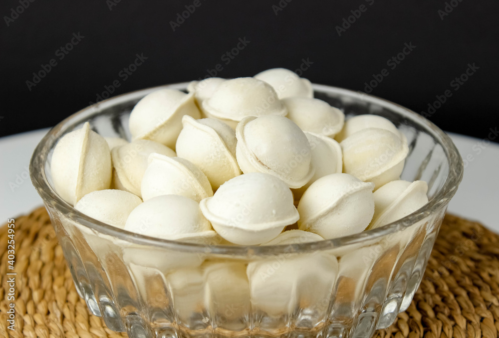 Frozen raw dumplings with meat in a transparent plate. Frozen raw dumplings with meat in a transparent plate.