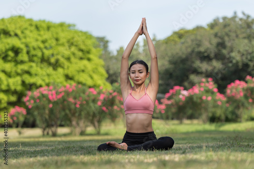 Asian woman doing yoga exercise and relax with sportswear in park