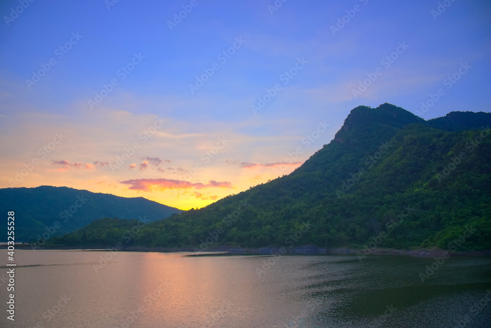 Landscape with mountain lake, reflection, blue sky and yellow sunlight in sunset, Thailand