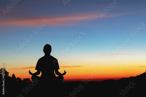 Silhouette of woman meditating at sunset.sport for weight loss concepts