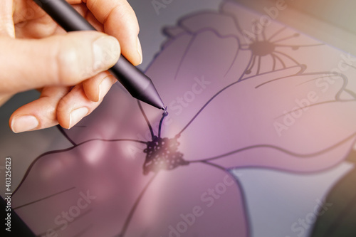 vector art - closeup of hand with digital pen drawing flower illustration on graphics tablet photo