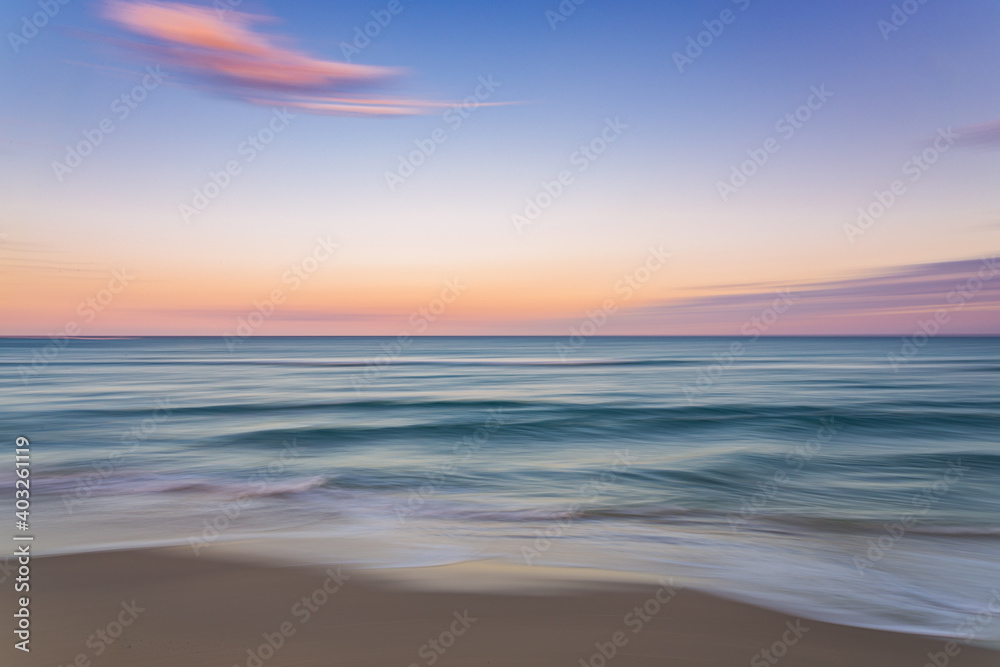 Palm Beach Island beach sunset with slow shutter pan of pink, blue and purple skies with green ocean water