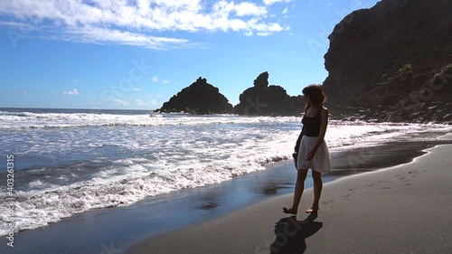 A young tourist walking along the beach of Nogales in the east of the island of La Palma, Canary Islands. Spain photo