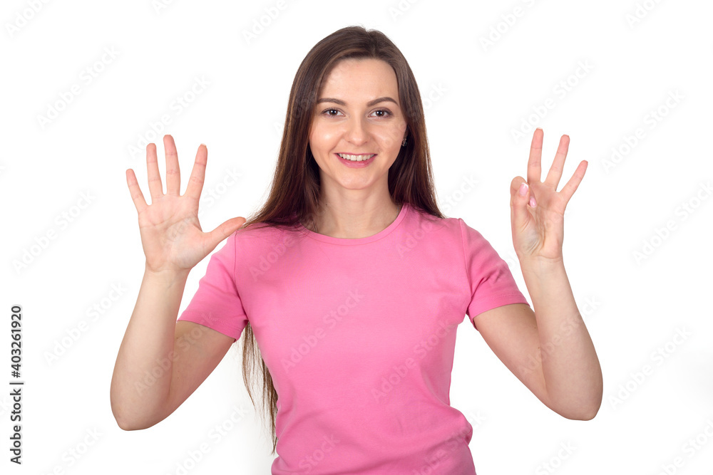 Young woman in a pink sweater shows 8 fingers as the number eight. Young woman in a pink sweater shows 8 fingers as the number eight.