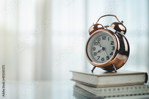 Bell alarm clock on books with copy space for time management for study and work concept