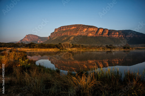 Landscape at sunrise with mountains and a lake which gives a nice reflection in Entabeni Game Reserve in the Waterberg Area in South Africa photo