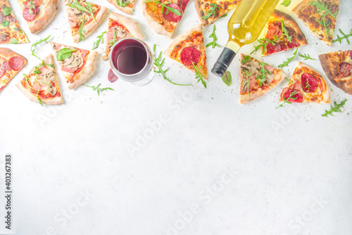 Pizza party concept.  Set of pizzas with various fillings, Pieces of different pizza, glass and bottle with wine. Flatlay top view copy space on white background