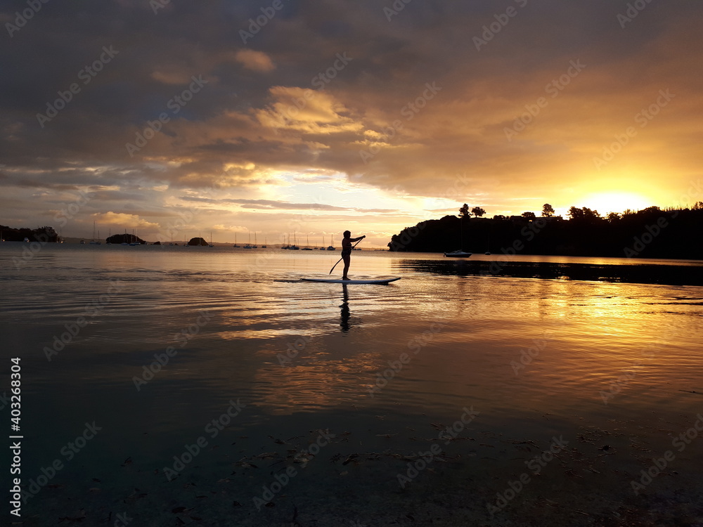 Woman on a paddleboard at sunset