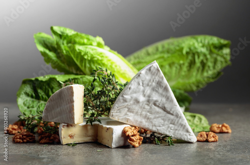 Fresh Brie cheese with lettuce, thyme, and walnuts.