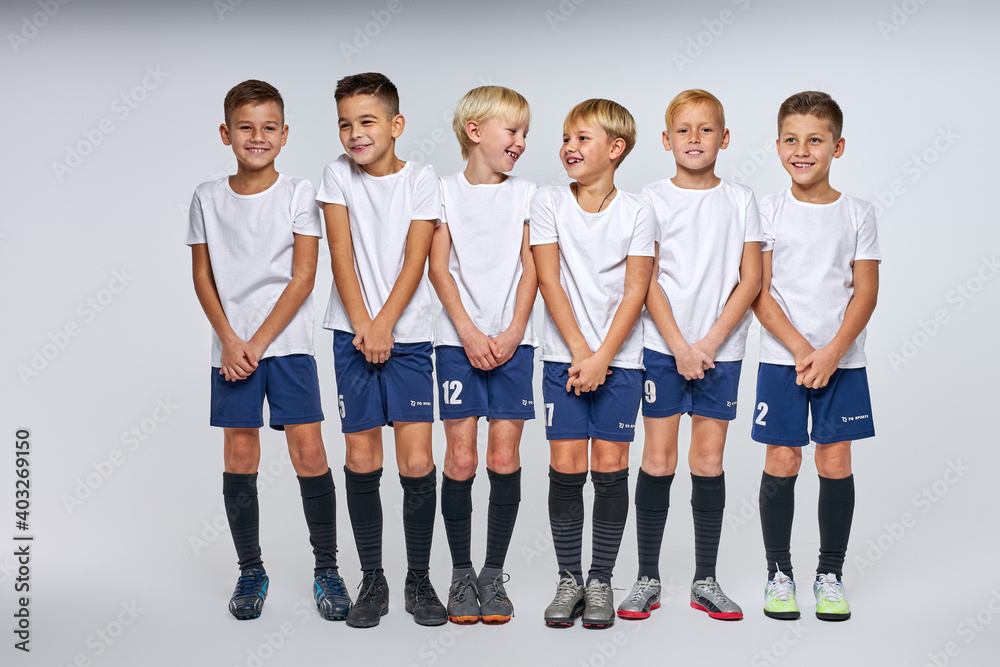 Fototapeta premium school boys in uniform stand defending the gate, boys in a row, football sport game concept