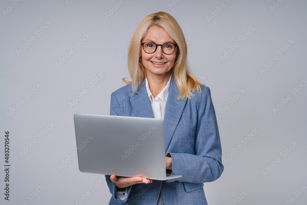 Cropped shot of senior business lady with laptop isolated over grey background Cropped shot of senior business lady with laptop isolated over grey background