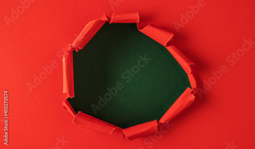 Red paper is torn over green background for message. Template for your text.