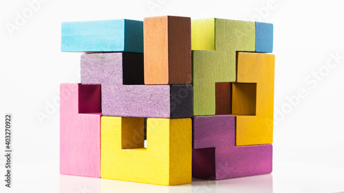 Cube made of multicolored wooden figures on a white background. Concept of logical thinking.