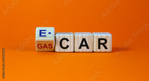 Gas car or e-car symbol. Turned a cube and changed words 'gas car' to 'e-car'. Beautiful orange background, copy space. Business and gas or electric car concept.