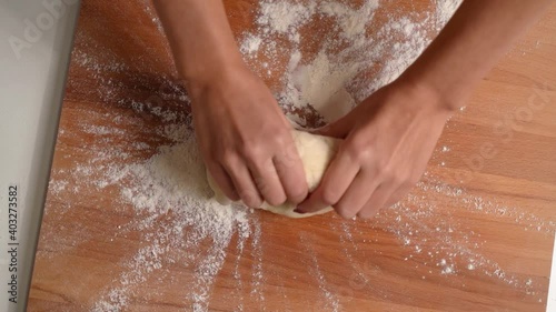 Wallpaper Mural Top view rotating of Baker kneading dough in flour on table. Woman hands is kneading dough on a wooden table. Italian homemade pizza Torontodigital.ca