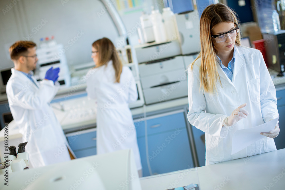 Female scientist in white lab coat standing in the biomedical lab Female scientist in white lab coat standing in the biomedical lab