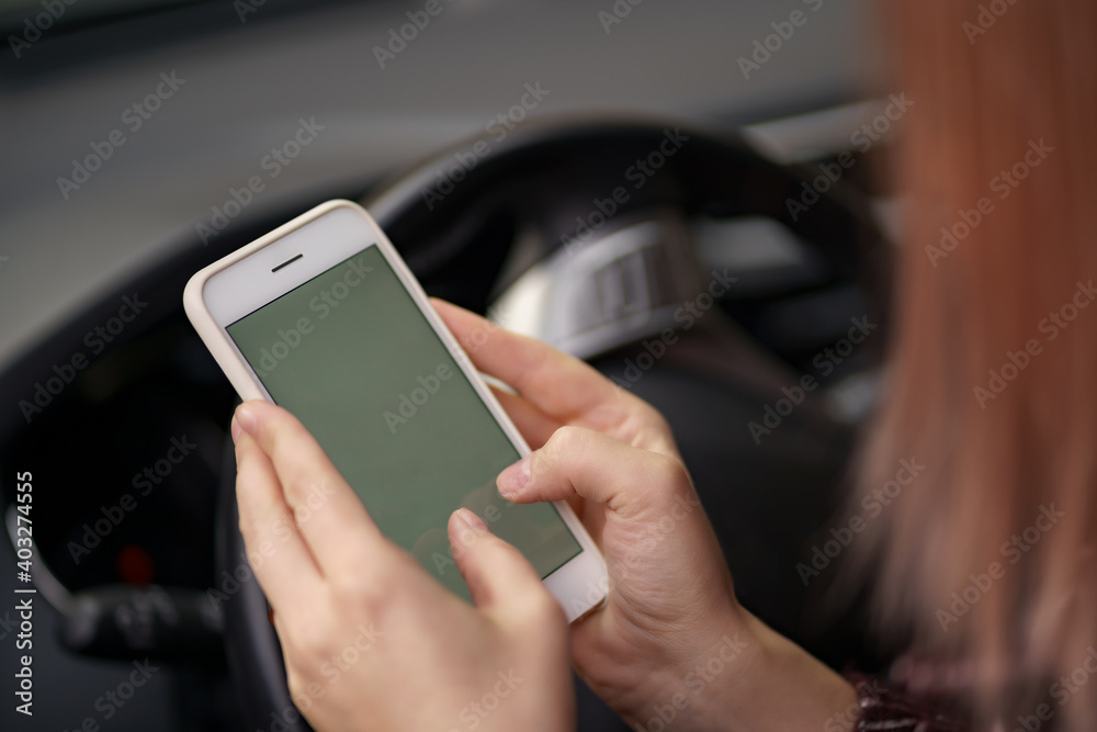 Mockup image of a woman holding, using mobile phone with blank screen while driver a car. Mockup image of a woman holding, using mobile phone with blank screen while driver a car.