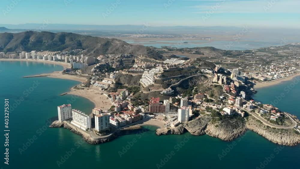 Aerial drone point of view Cullera sandy empty beach and townscape rooftops during sunny winter day. Touristic famous place. Province of Alicante, Costa Blanca, Spain Aerial drone point of view Cullera sandy empty beach and townscape rooftops during sunny winter day. Touristic famous place. Province of Alicante, Costa Blanca, Spain