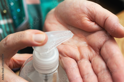 Senior woman hands using sanitizer gel for disinfection and prevent coronavirus  Covid-19 infection  cleaning palms with antibacterial antiseptic  close-up view