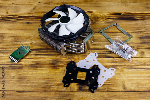 Modern CPU cooler with installation kit on a wooden desk photo