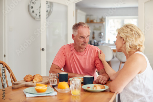 Senior Woman Comforting Man Suffering With Depression At Breakfast Table At Home © Monkey Business