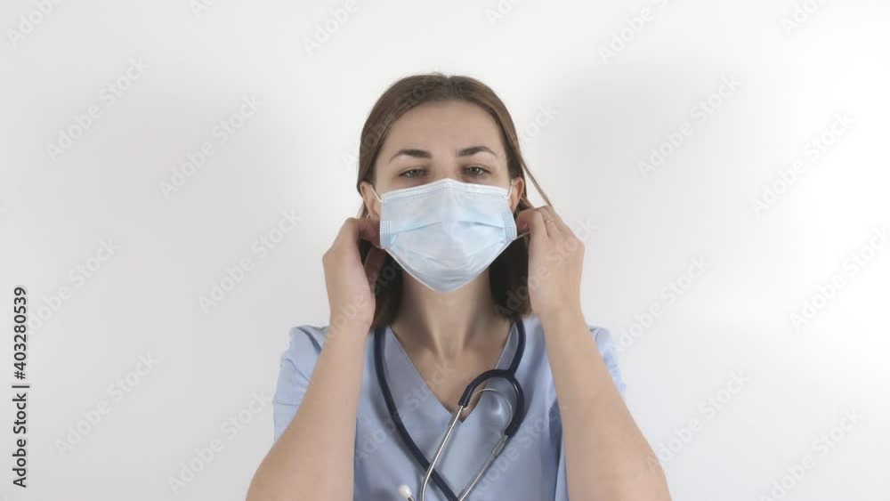 Young woman doctor takes off the mask. Nurse after shift in the red zone. High quality 4k footage Young woman doctor takes off the mask. Nurse after shift in the red zone. High quality 4k footage