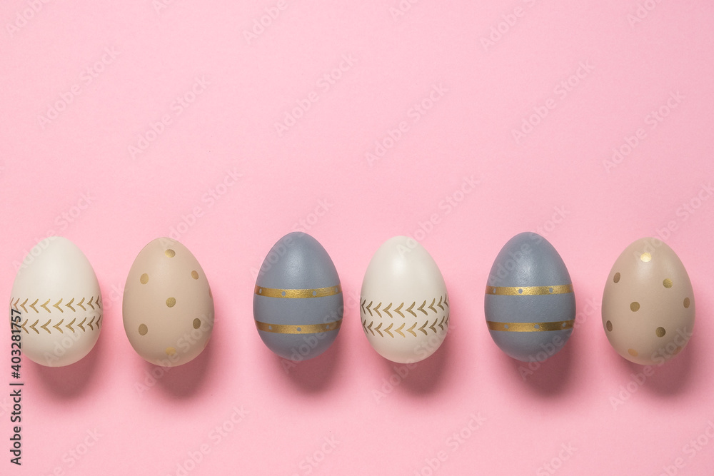 Easter concept. decorated eggs stand in a row on pink background. Minimal easter concept. Happy Easter card with copy space for text. Top view, flatlay