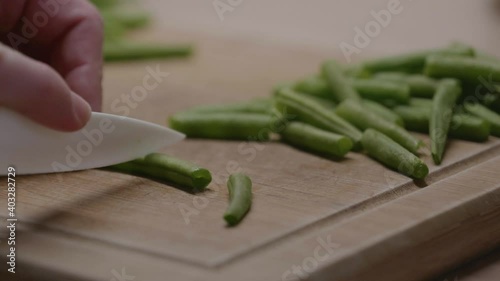 Une femme qui découpe des haricots verts