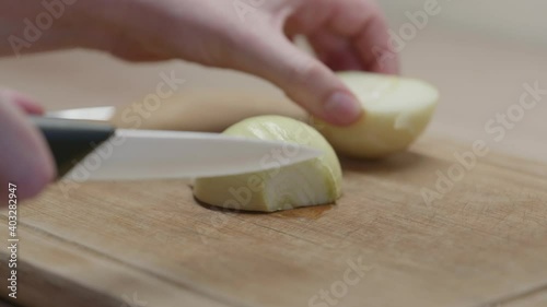Une femme qui découpe un oignon sur une planche