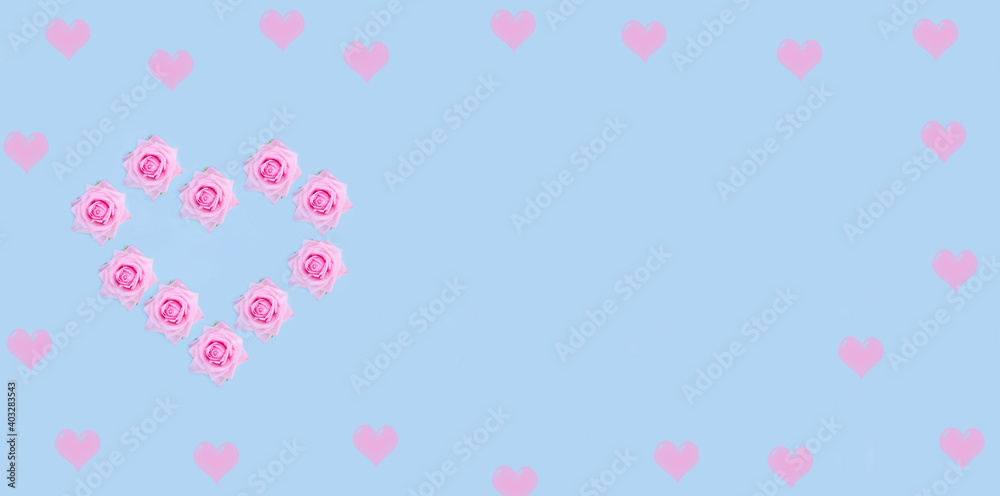Valentine's Day banner background. Pink roses in the shape of a heart on a pastel blue background with copy space.