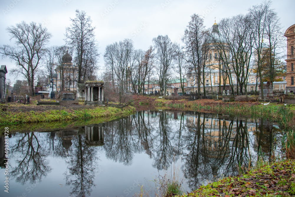 An autumn view on the Monastery Island with churches at the back and an old cemetery reflecting in the pond, Saint Petersburg, Russia
