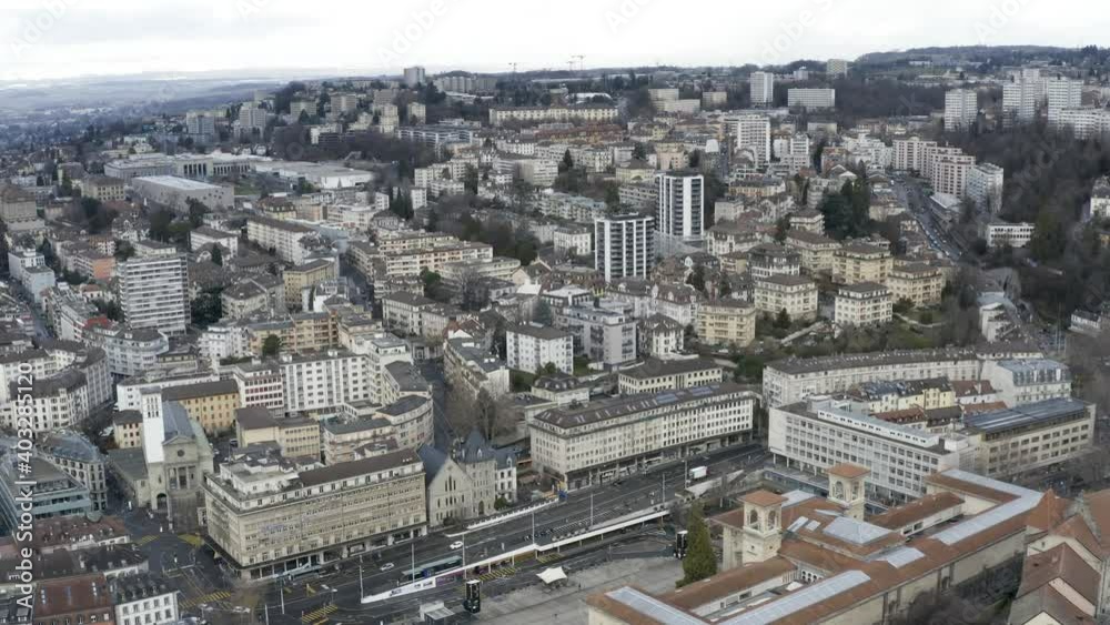Drone Aerial of the swiss town and the cathedral of Lausanne. The winter has just begun in Switzerland and the mountains above the lake geneva (lac léman) are covered in snow.