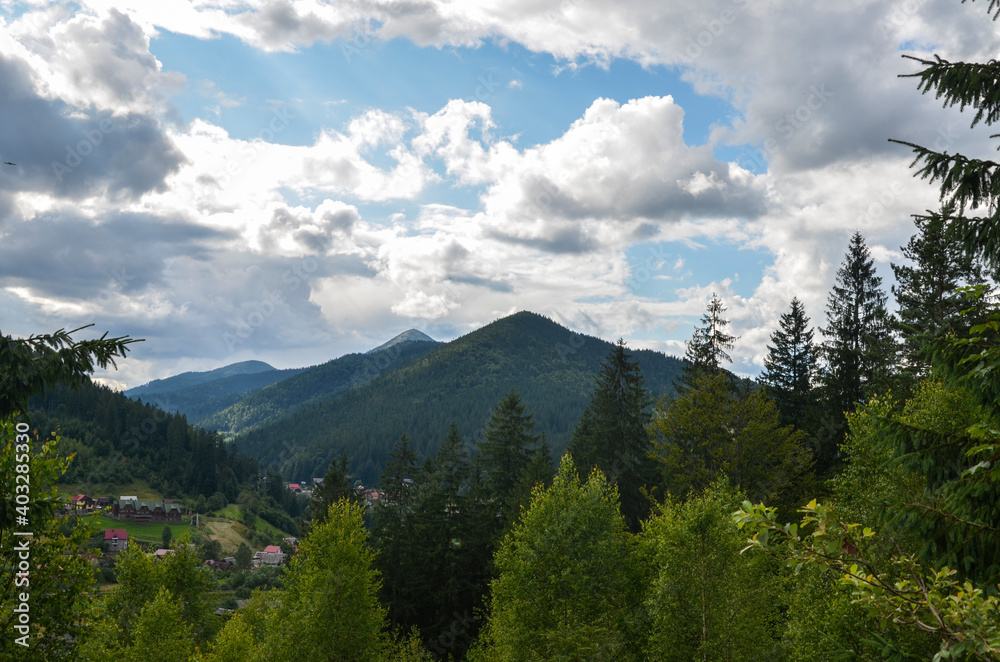 Picturesque summer view of the valley with the village Tatariv at the foot of the Carpathian Mountains, Ukraine
