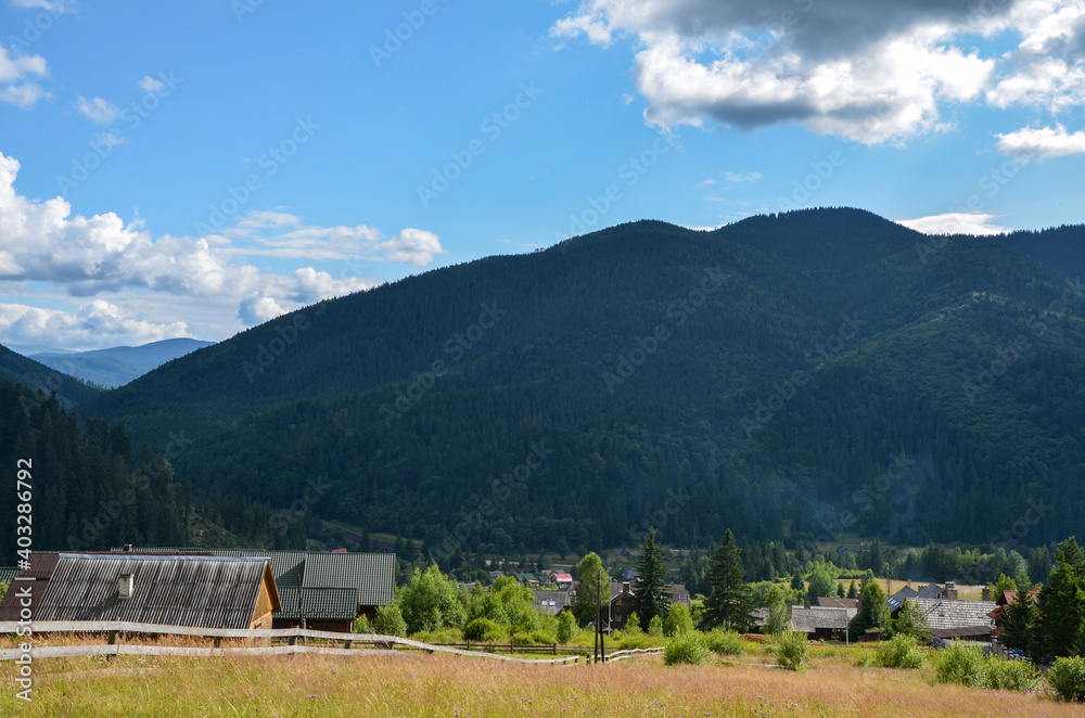 Picturesque summer view of the valley with the village Tatariv at the foot of the Carpathian Mountains, Ukraine