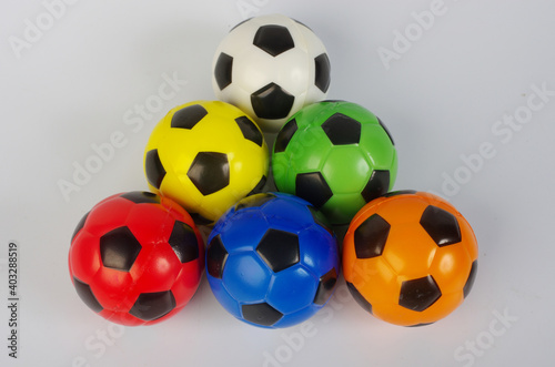 Fototapeta Naklejka Na Ścianę i Meble -  Multi-colored toy soccer balls on a light background.