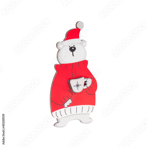 Wooden decoration in form of polar bear drinking cup of hot coffee wearing red sweater and pompom hat isolated on white background 