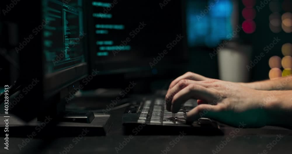 A computer programmer or hacker prints a code on a laptop keyboard to break into a secret organization system.