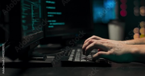 A computer programmer or hacker prints a code on a laptop keyboard to break into a secret organization system.